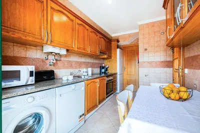 a kitchen with a washing machine and a microwave at Villa Gil in Albufeira
