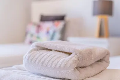 a stack of towels sitting on top of a bed at Villa Gil in Albufeira