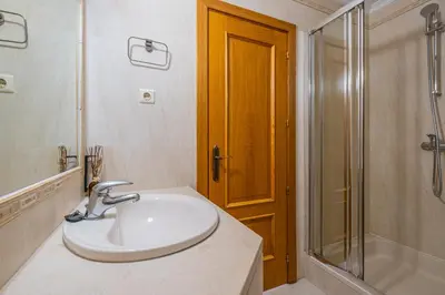 a white bathroom with a sink and a shower at Villa Gil in Albufeira