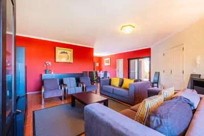a living room with red walls and couches at Orange Tree House in Albufeira