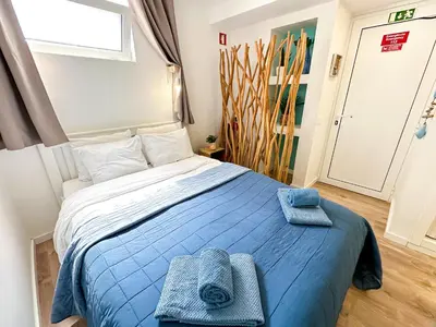 a kitchen with blue walls and wooden floors and a counter at BnB Homes Falésia Beach cozy Apartment with terrace & 2 Swimming Pools in Roja- Pé