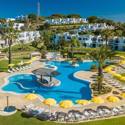 an aerial view of a resort pool with chairs and umbrellas at ADO HOUSE Albufeira in Albufeira