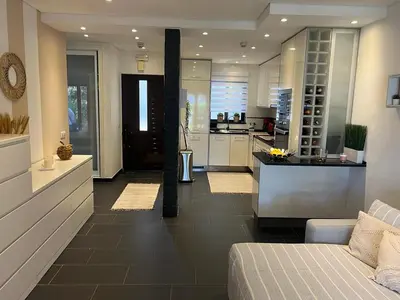 a large kitchen with a couch and a counter at ADO HOUSE Albufeira in Albufeira