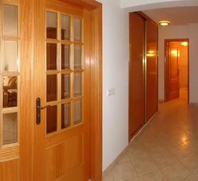 a corridor with a wooden door and a hallway with at Apartamento Avenida da Liberdade in Albufeira
