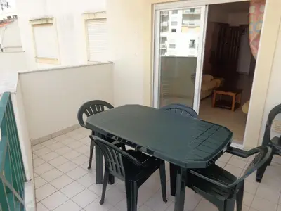 a green table and chairs in a room at Apartamento Avenida da Liberdade in Albufeira