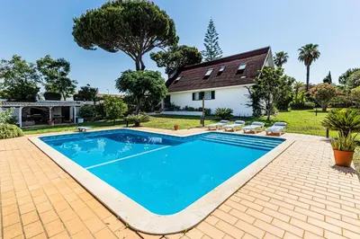 a swimming pool in front of a house at Villa Oliva - Maison 6 chambres in Vilamoura