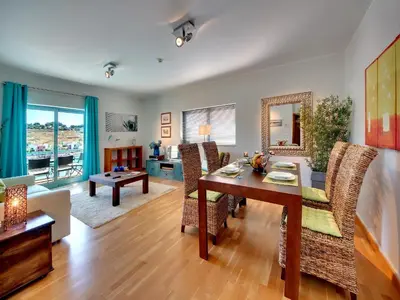 a living room with a table and a dining room at Marina Sea Residence in Albufeira