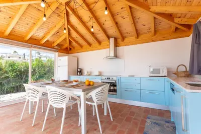 a kitchen with blue cabinets and a table with chairs at Villa Matibora by HelloVacations in Albufeira