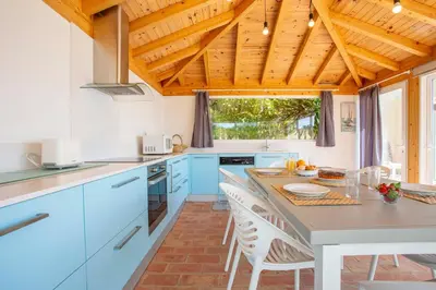 a kitchen with blue cabinets and a wooden ceiling at Villa Matibora by HelloVacations in Albufeira