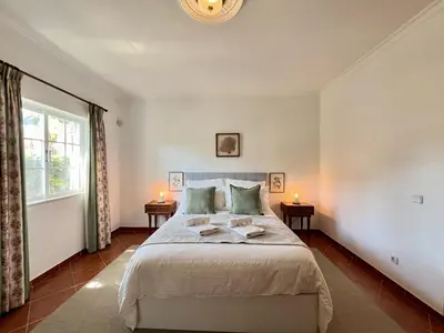 a bedroom with a large bed with two tables at Vilamoura White House Villa With Pool by Homing in Vilamoura