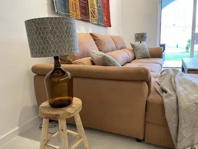a living room with a couch and a lamp on a stool at Modern Apartment with balcony and direct access to the pool in Albufeira