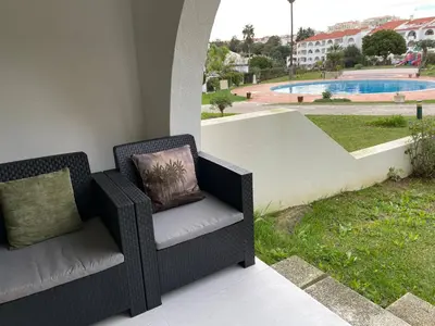 two chairs on a patio with a view of a pool at Modern Apartment with balcony and direct access to the pool in Albufeira