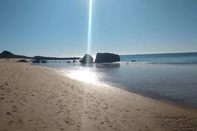 a water fountain on a beach near the ocean at Beach Front Luxury T1 Apt Pools Garage Tennis in Albufeira