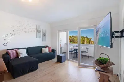 a living room with a couch and a tv and a table at Happy&Roses, Vilamoura, pool&golf in Vilamoura