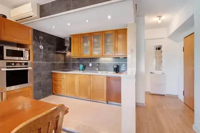 a kitchen with wooden cabinets and a table in it at Happy&Roses, Vilamoura, pool&golf in Vilamoura