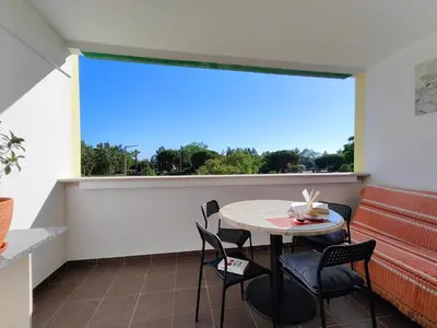 a balcony with a table and chairs and a large window at Happy&Roses, Vilamoura, pool&golf in Vilamoura