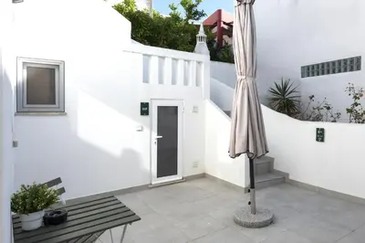 a picnic table and two stools on a balcony at Casa São Francisco Old Town Faro in Faro