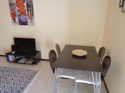 a dining room with a black table and chairs at Apartamento Praia dos Salgados in Albufeira