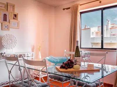 a dining room with a glass table and a bottle of wine at Albufeira Boho Apartment in Albufeira