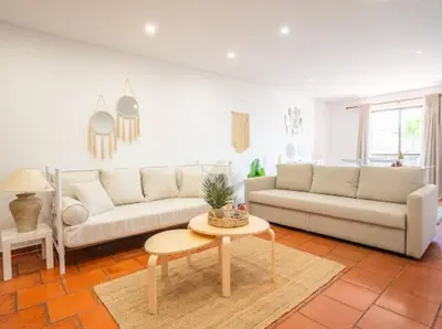 a living room with two couches and a table at Albufeira Boho Apartment in Albufeira