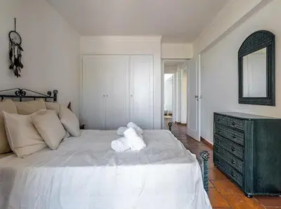 a teddy bear sitting on a bed in a bedroom at Albufeira Boho Apartment in Albufeira