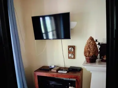 a flat screen tv hanging on a wall at Nice flat in pretty condo in Quarteira