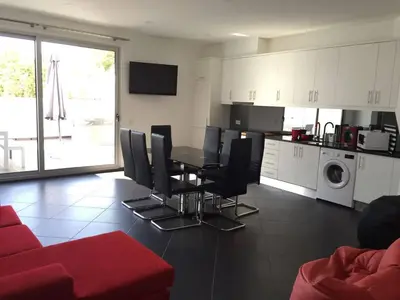 a living room with a table and chairs and a kitchen at Casa com 3 suites, jacuzzi , en Albufeira in Albufeira
