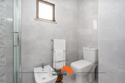a bathroom with a toilet and a shower with a window at #232 Vila Girasol 33 by Home Holidays in Albufeira