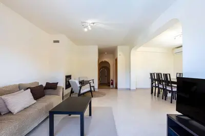 a living room with a couch and tables and chairs at Villa Moura by HelloVacations in Loulé