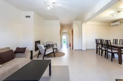 a living room with a couch and a table and chairs at Villa Moura by HelloVacations in Loulé