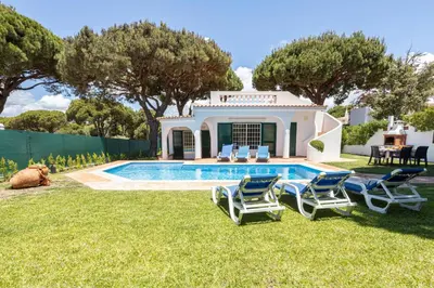 a villa with a swimming pool in a yard at Villa Moura by HelloVacations in Loulé