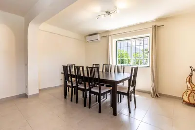 a dining room with a table and chairs and a window at Villa Moura by HelloVacations in Loulé