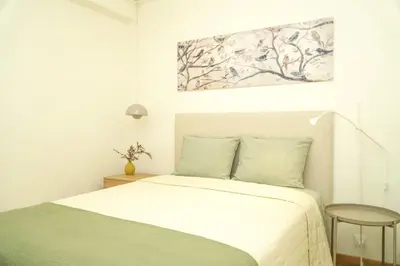 a bedroom with a bed and a painting on the wall at Pilar Apartment in Albufeira