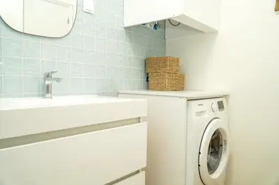 a bathroom with a washing machine and a sink at Pilar Apartment in Albufeira