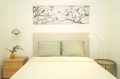 a bedroom with a bed with a painting on the wall at Pilar Apartment in Albufeira