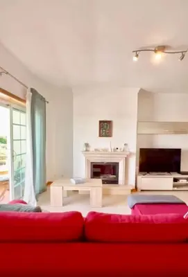 a living room with a red couch and a fireplace at Casa do Mar Faro in Faro