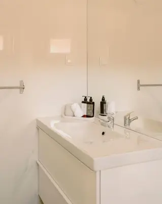 a white bathroom with a sink and a mirror at Glam House no coração da cidade in Faro