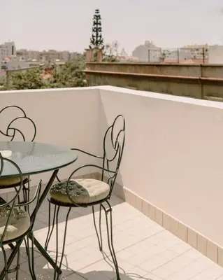 a patio with two tables and chairs on a balcony at Glam House no coração da cidade in Faro
