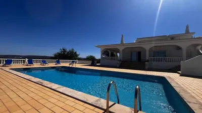 a swimming pool with blue chairs and a white fence at BnB Homes Luxurious Villa Stardust with Swimming pool & BBQ for Family Fun in Ameijoafas