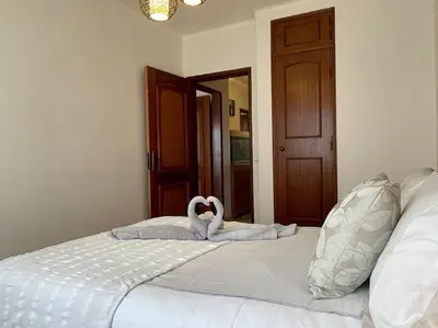 two swans laying on a bed in a bedroom at The Luna Apartment Faro - 2 Bedroom Private Apartment in Faro