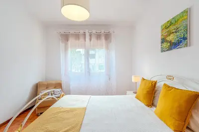 a bedroom with a bed with yellow pillows and a window at Apartamento Briza by Sunnyway in Albufeira