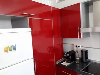 a kitchen with red cabinets and a red wall at Charming house with terrace near the city center in Faro