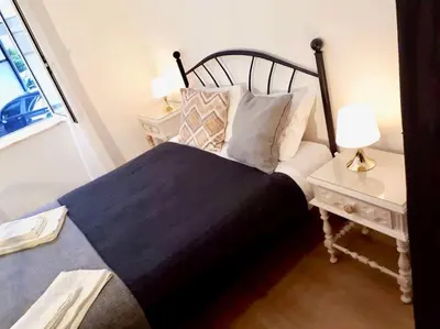 a bedroom with a large bed and two night stands at Charming house with terrace near the city center in Faro