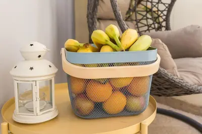 a basket of fruit on a table next to a lantern at Charming house with terrace near the city center in Faro