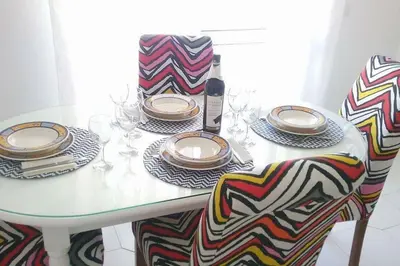 a table with plates and glasses and a bottle of wine at Color me Happy - 2 bedrooms apartment near Forum Algarve in Faro
