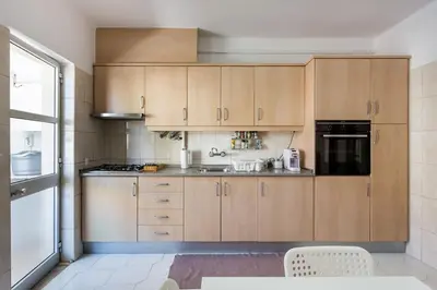a kitchen with wooden cabinets and a sink at Color me Happy - 2 bedrooms apartment near Forum Algarve in Faro