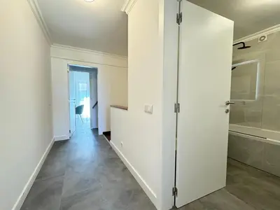 a hallway with white walls and a glass door at Casa Coral Azul in Albufeira