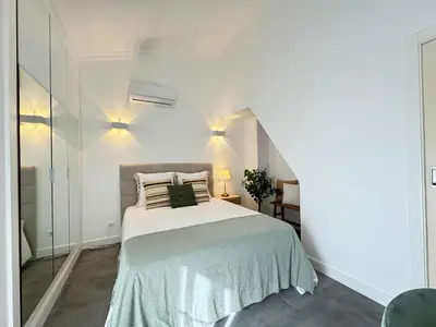 a white bedroom with a bed and a staircase at Casa Coral Azul in Albufeira