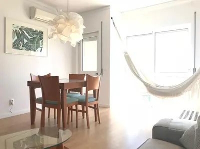 a dining room with a wooden table and chairs at Home away from Home in Faro