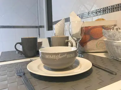 a table with a cup and a plate and a wine glass at Home away from Home in Faro